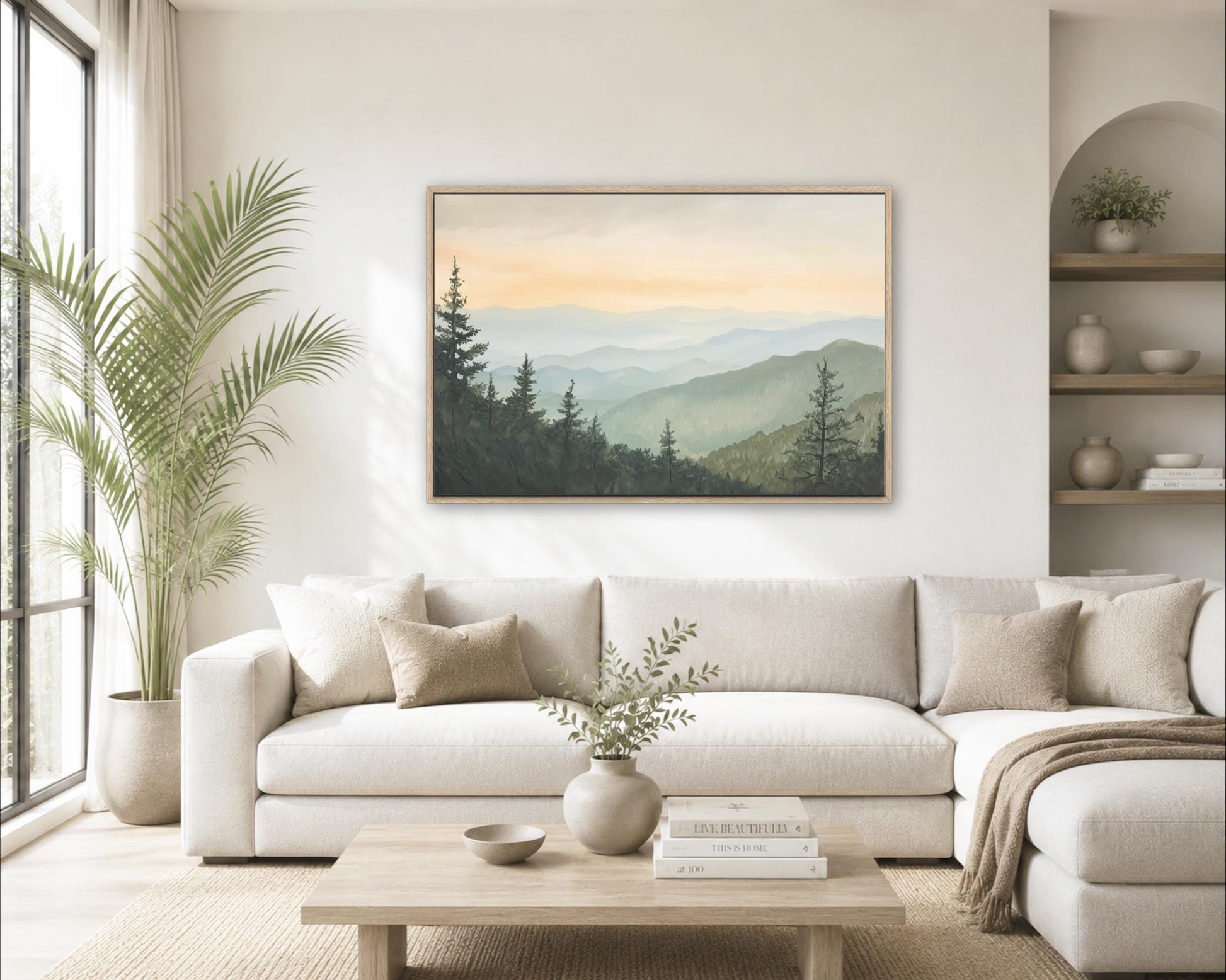 a serene living room with a large painting of a mountain landscape hanging on the wall above a white sofa. The room is decorated with various plants and has a wooden coffee table in the center.