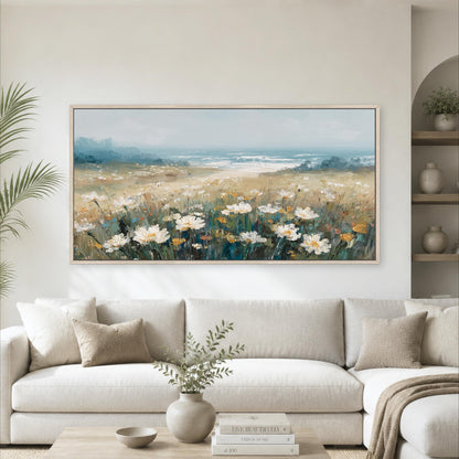 a large painting of a field of flowers hanging on a wall above a white sofa in a living room.