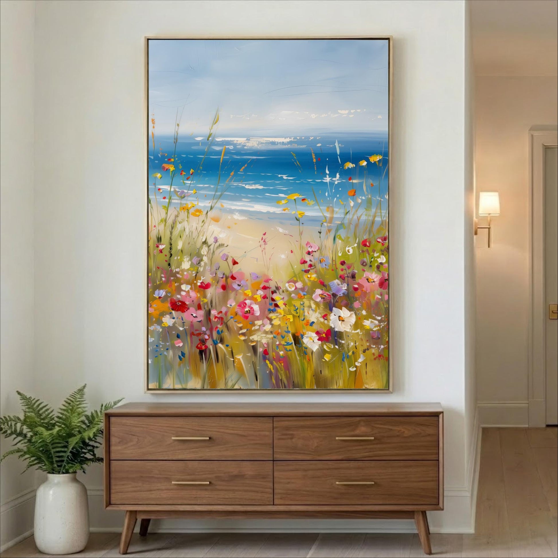 a large painting of a vibrant field of flowers hanging on a wall above a wooden dresser.