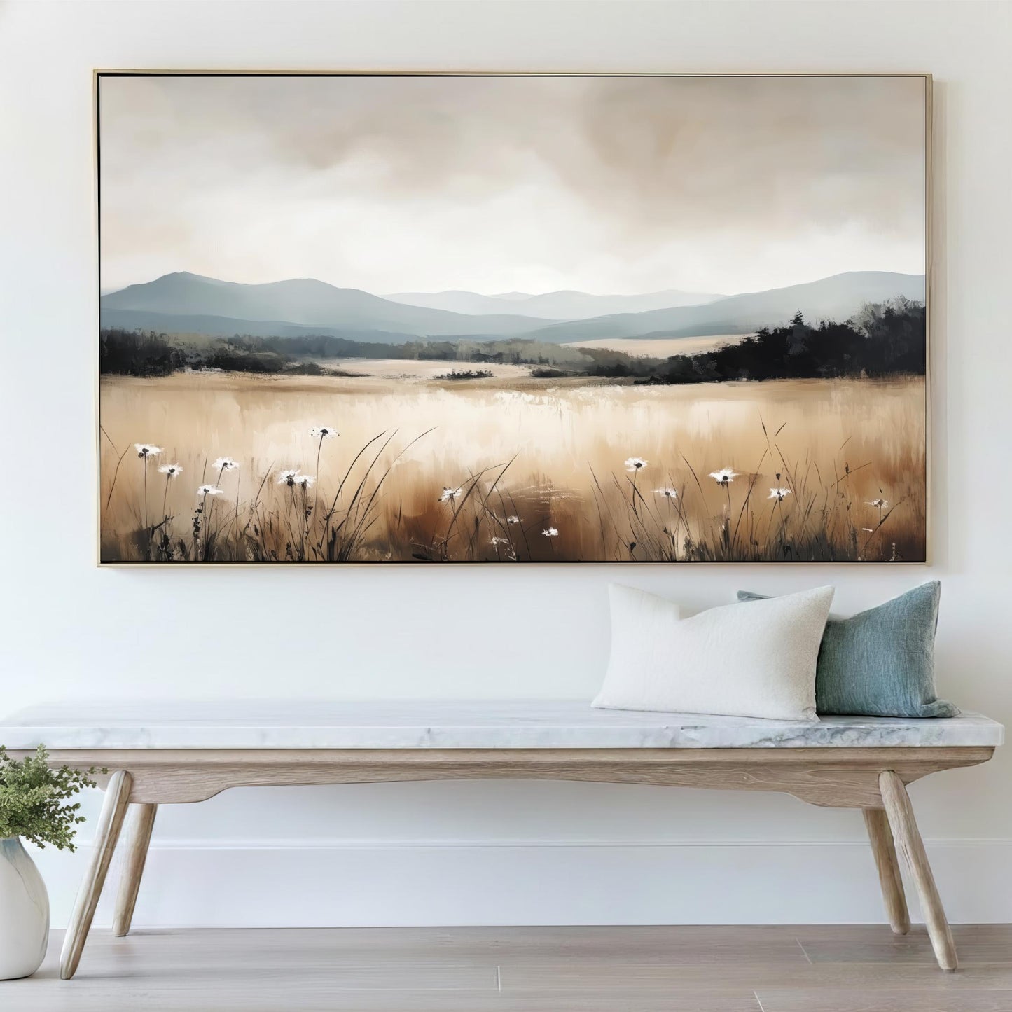 a large landscape painting hanging on a wall above a wooden bench with pillows.