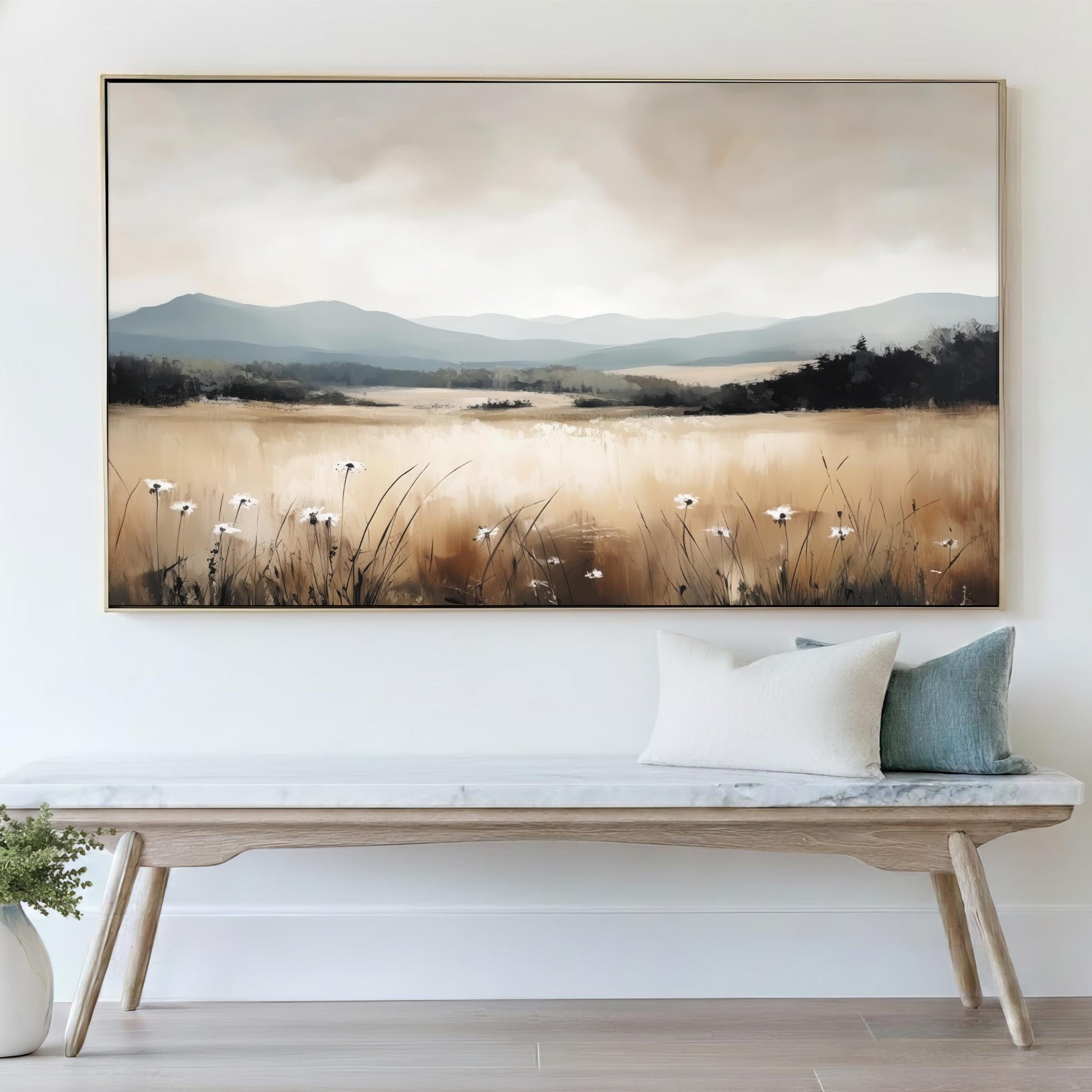a large landscape painting hanging on a wall above a wooden bench with pillows.