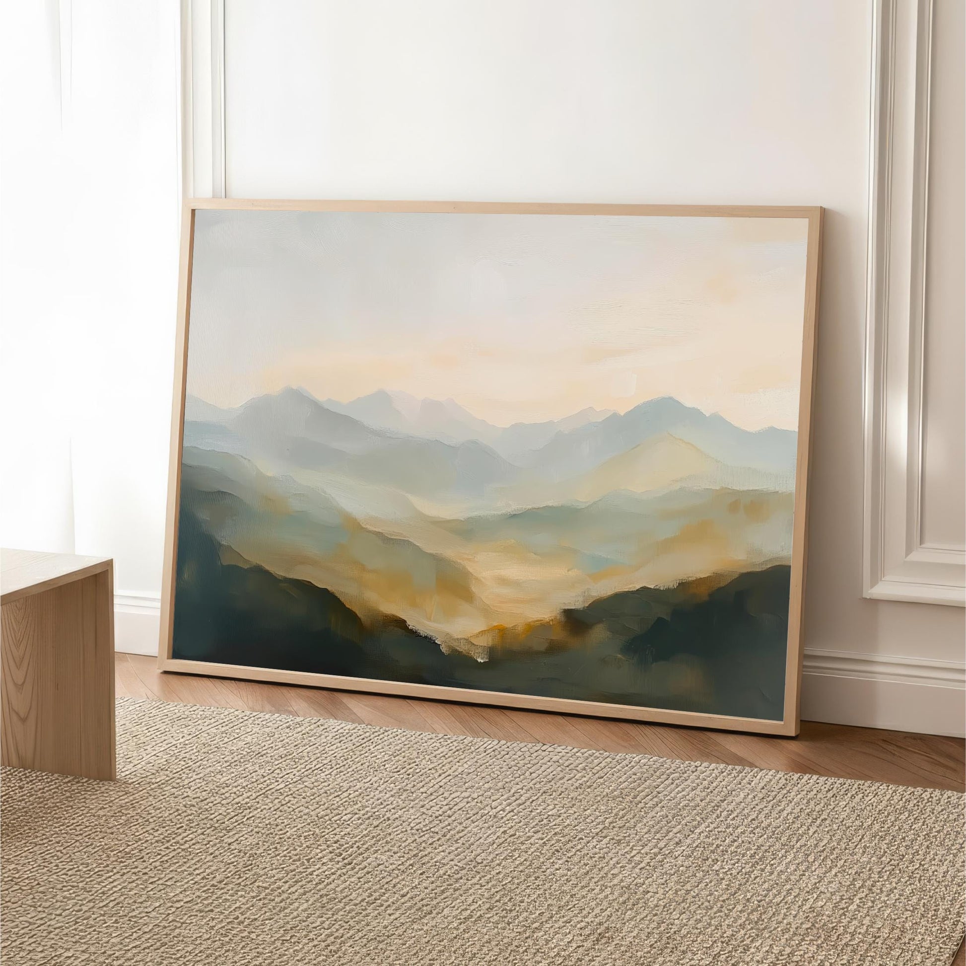 a large landscape painting hanging on a wall, depicting a mountainous scene with a hazy, golden-hued background.