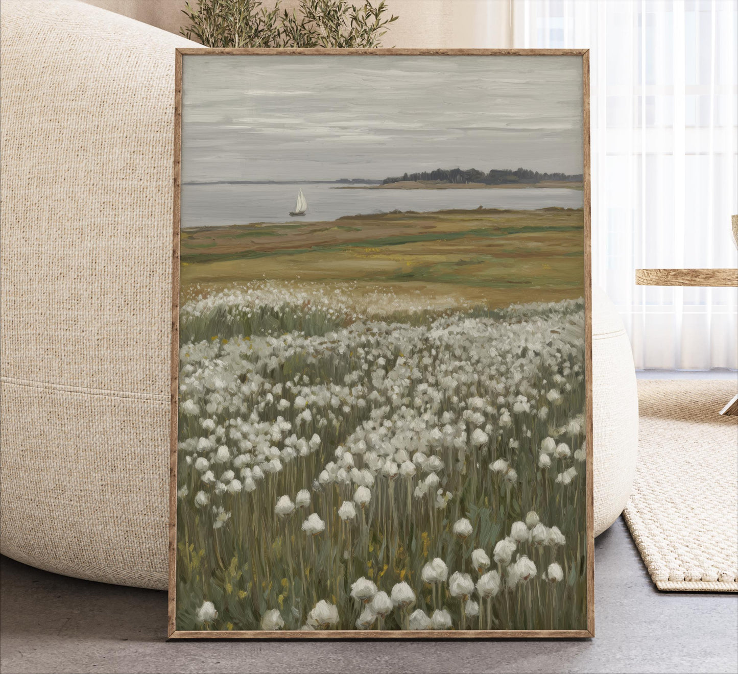 The image is a framed painting depicting a serene landscape with a field of white flowers, a sailboat on the water, and a distant island in the background.