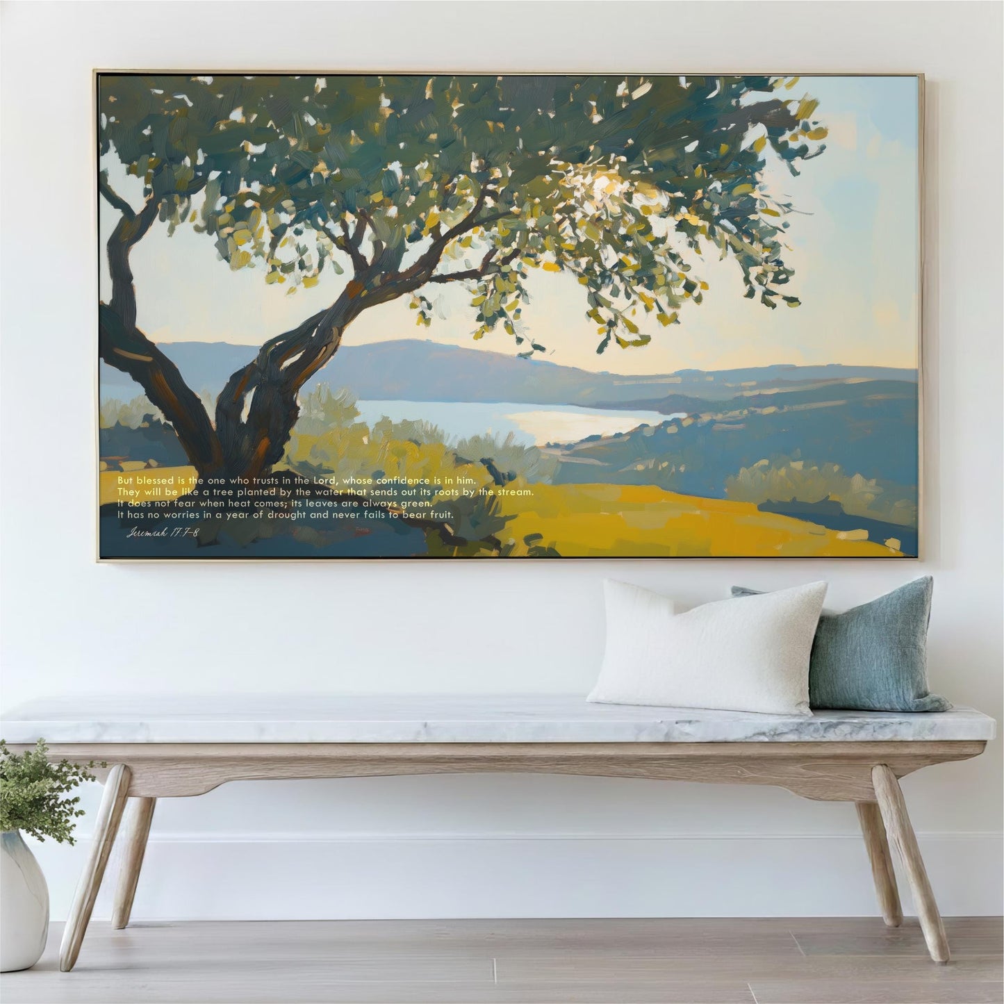 a large painting of a tree with a serene landscape in the background, hanging on a wall above a wooden bench with pillows.