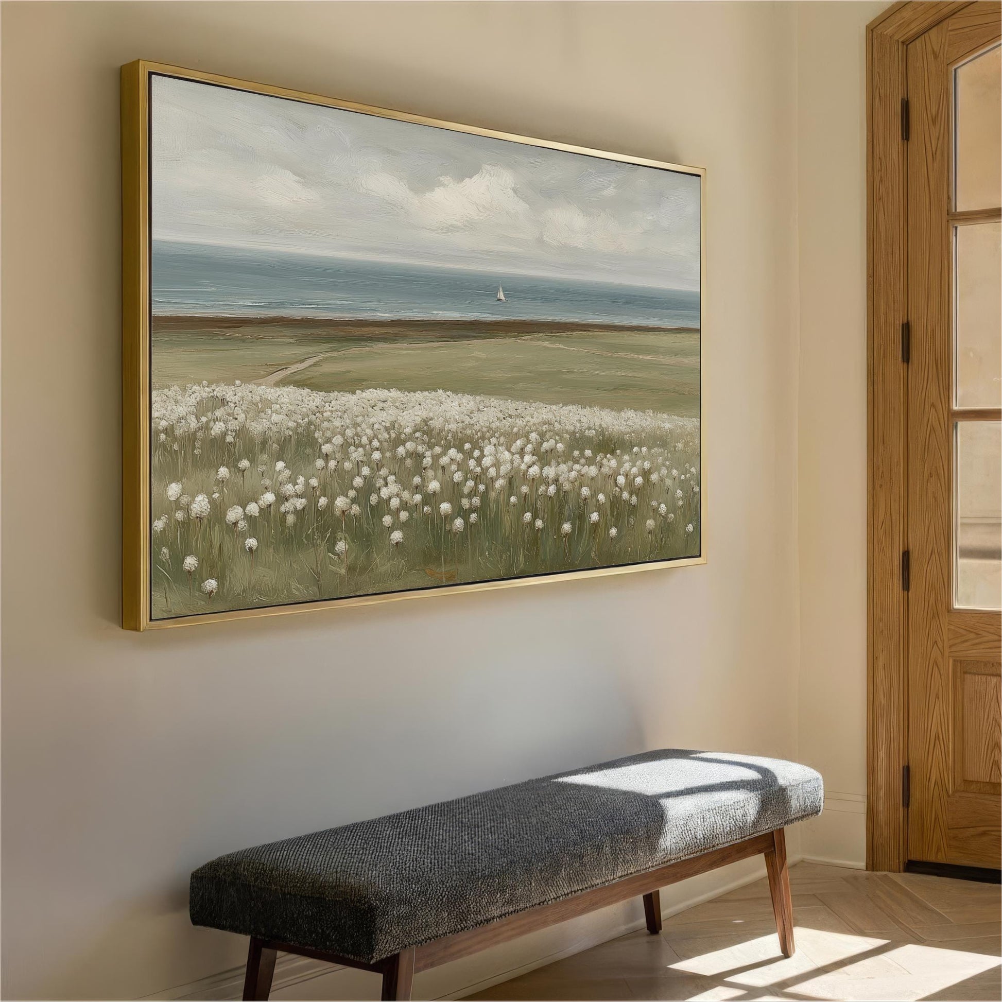 a large painting of a field with white flowers hanging on a wall, and a bench is positioned below the painting.