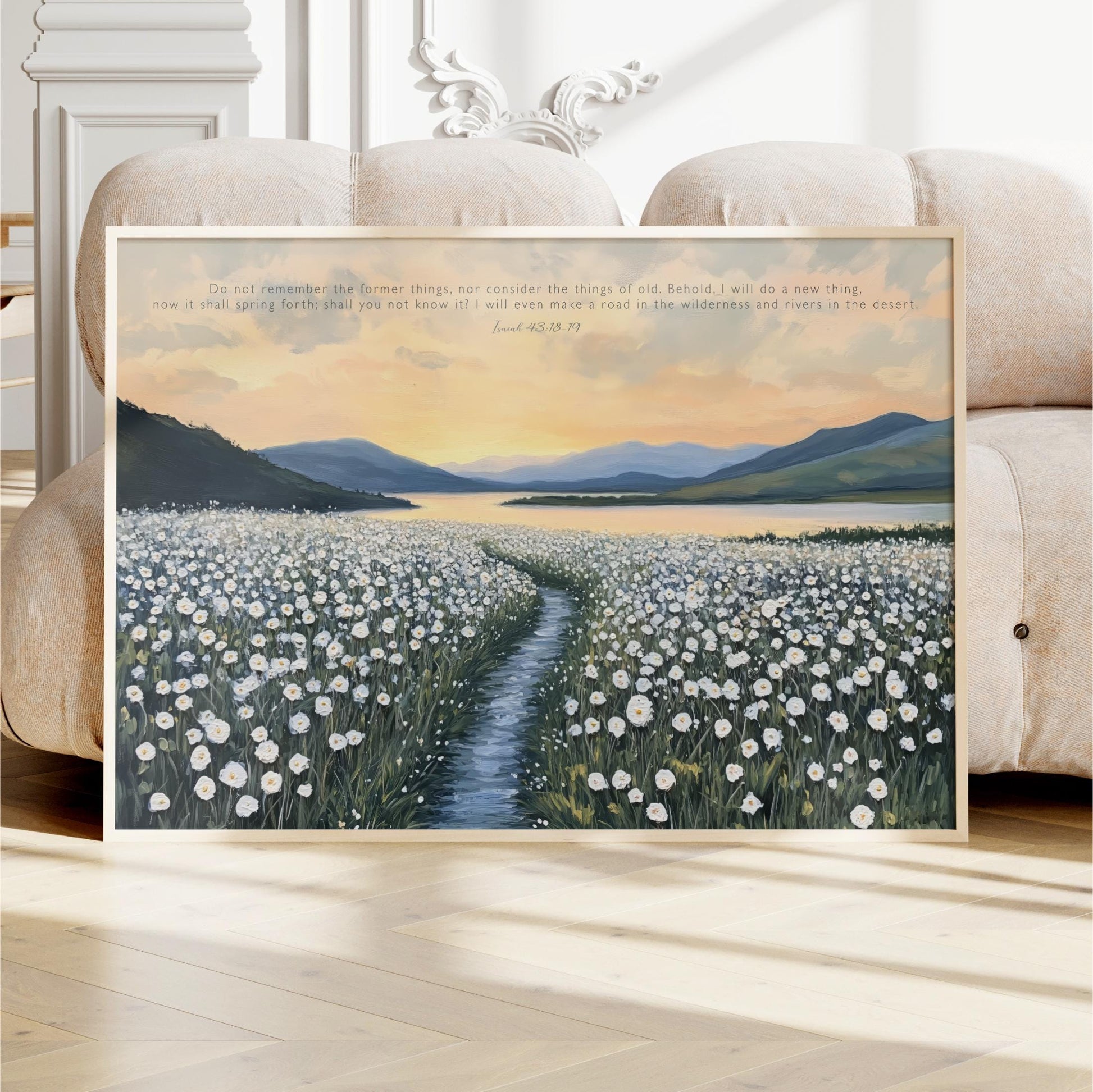 The image is a framed painting depicting a field of white flowers with a winding path leading through it, set against a backdrop of mountains and a sunset sky.