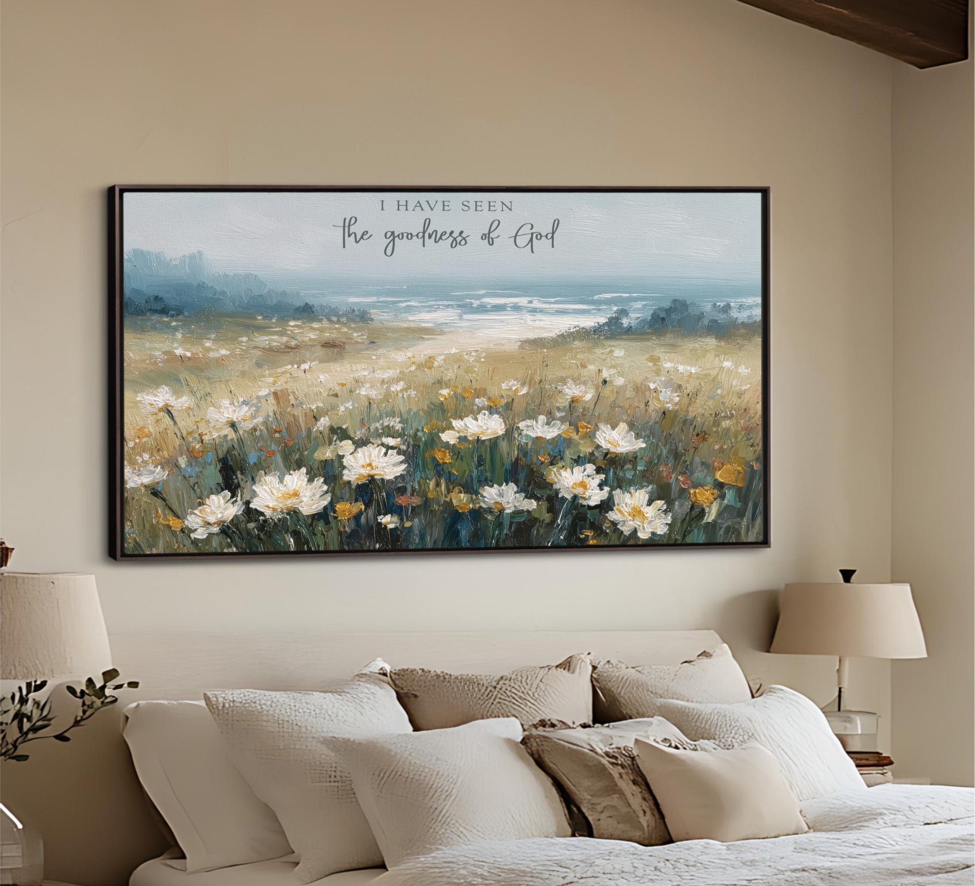 a large painting of a field of flowers hanging on a wall above a bed with white pillows and a beige headboard.