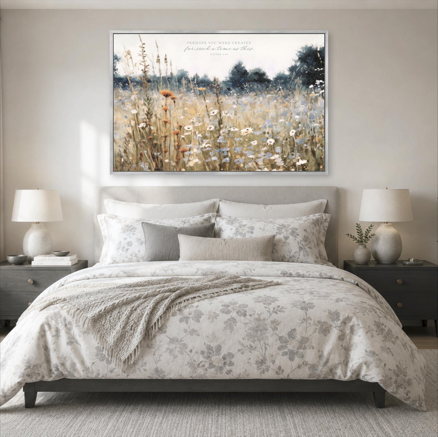 a serene bedroom scene with a large bed adorned with a floral comforter and pillows, flanked by two nightstands with lamps. Above the bed, a large framed painting of a field of flowers is displayed on the wall, creating a peaceful and inviting atmosphere.