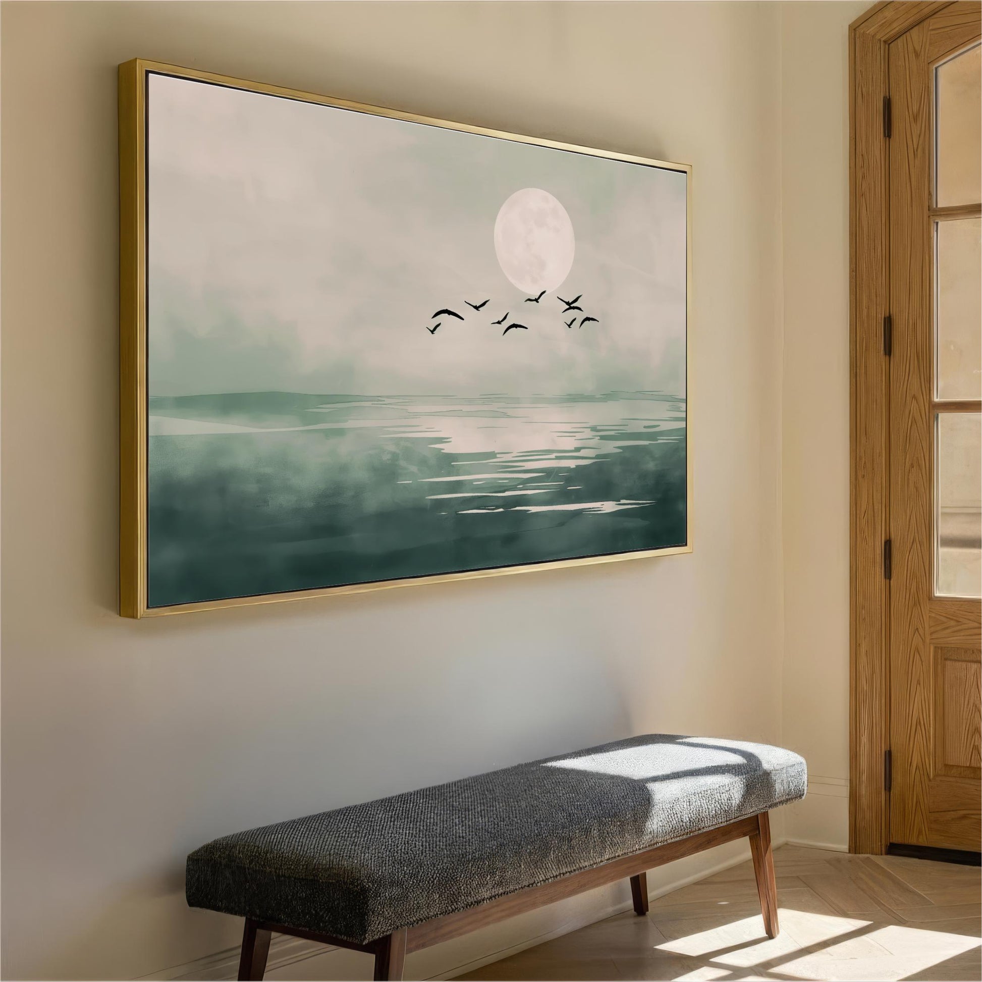 a large framed painting of a serene landscape with a full moon, birds flying in the sky, and a body of water reflecting the moon. The painting is hanging on a wall, and there is a bench in the foreground.