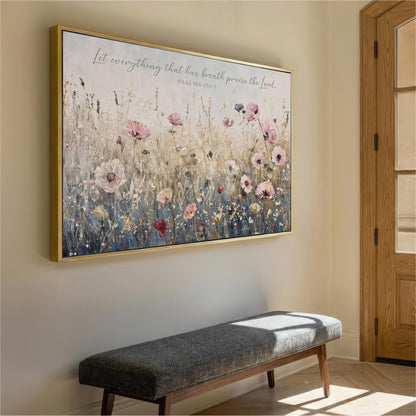 a large framed painting of a field of flowers hanging on a wall, with a wooden bench placed in front of it.