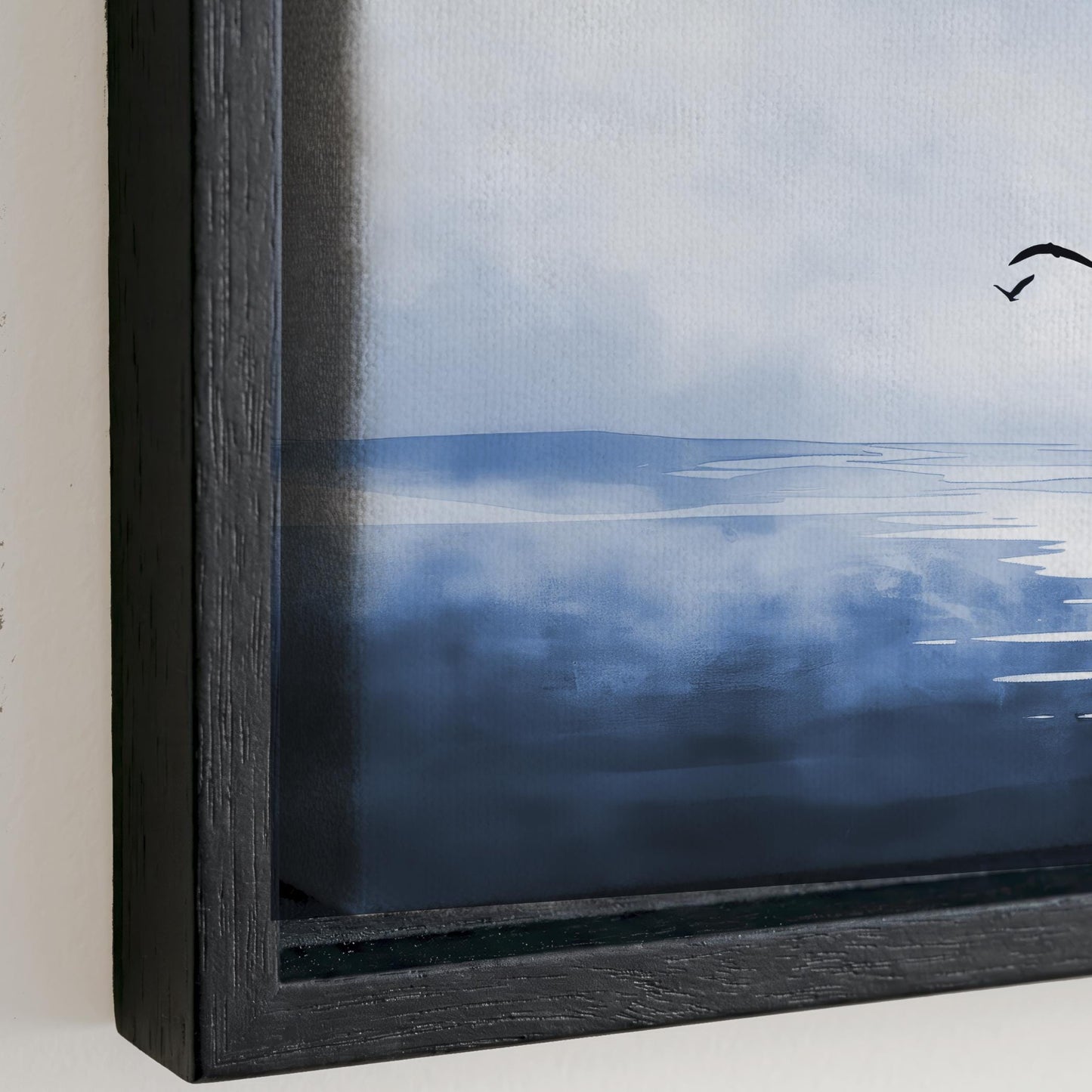 The image is a framed painting depicting a serene landscape with a body of water and a cloudy sky.