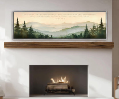 a fireplace with a warm fire burning inside, surrounded by a serene landscape of mountains and pine trees. Above the fireplace, there is a framed quote from the Bible, specifically Proverbs 22:6, which reads "Trust in the LORD with all your heart, and lean not on your own understanding. In all your ways acknowledge Him, and he shall direct your path."