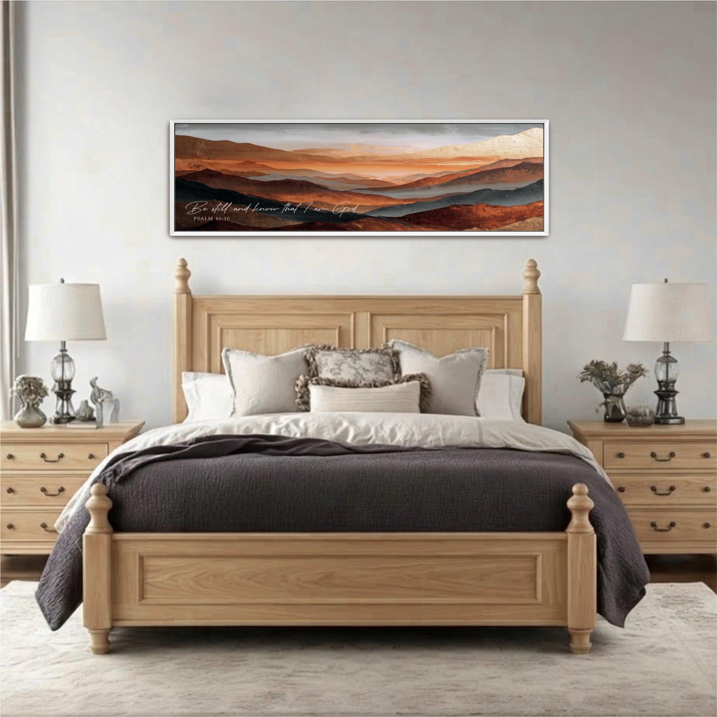 a large wooden bed with a gray comforter and pillows, flanked by two nightstands with lamps. Above the bed is a framed landscape painting depicting a mountainous scene.