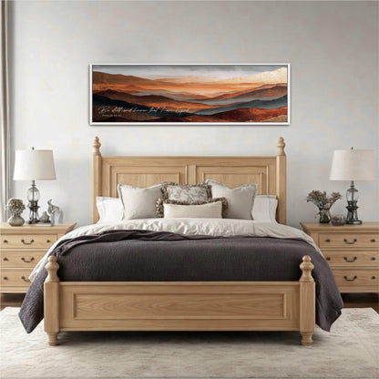 a large wooden bed with a gray comforter and pillows, flanked by two nightstands with lamps. Above the bed is a framed landscape painting depicting a mountainous scene.