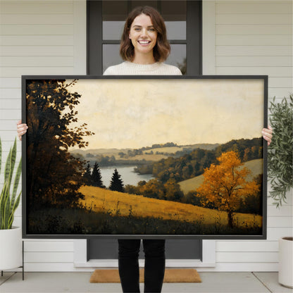 A woman is holding a large framed painting of a countryside landscape, which features a field, trees, and a body of water.