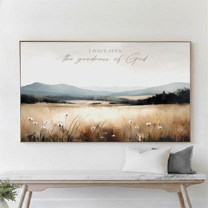 a large framed painting of a field with flowers hanging on a wall above a wooden bench.