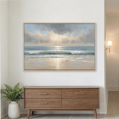 a large framed painting of a serene beach scene with waves crashing on the shore, set against a cloudy sky. The painting is hung on a white wall above a wooden dresser with four drawers.