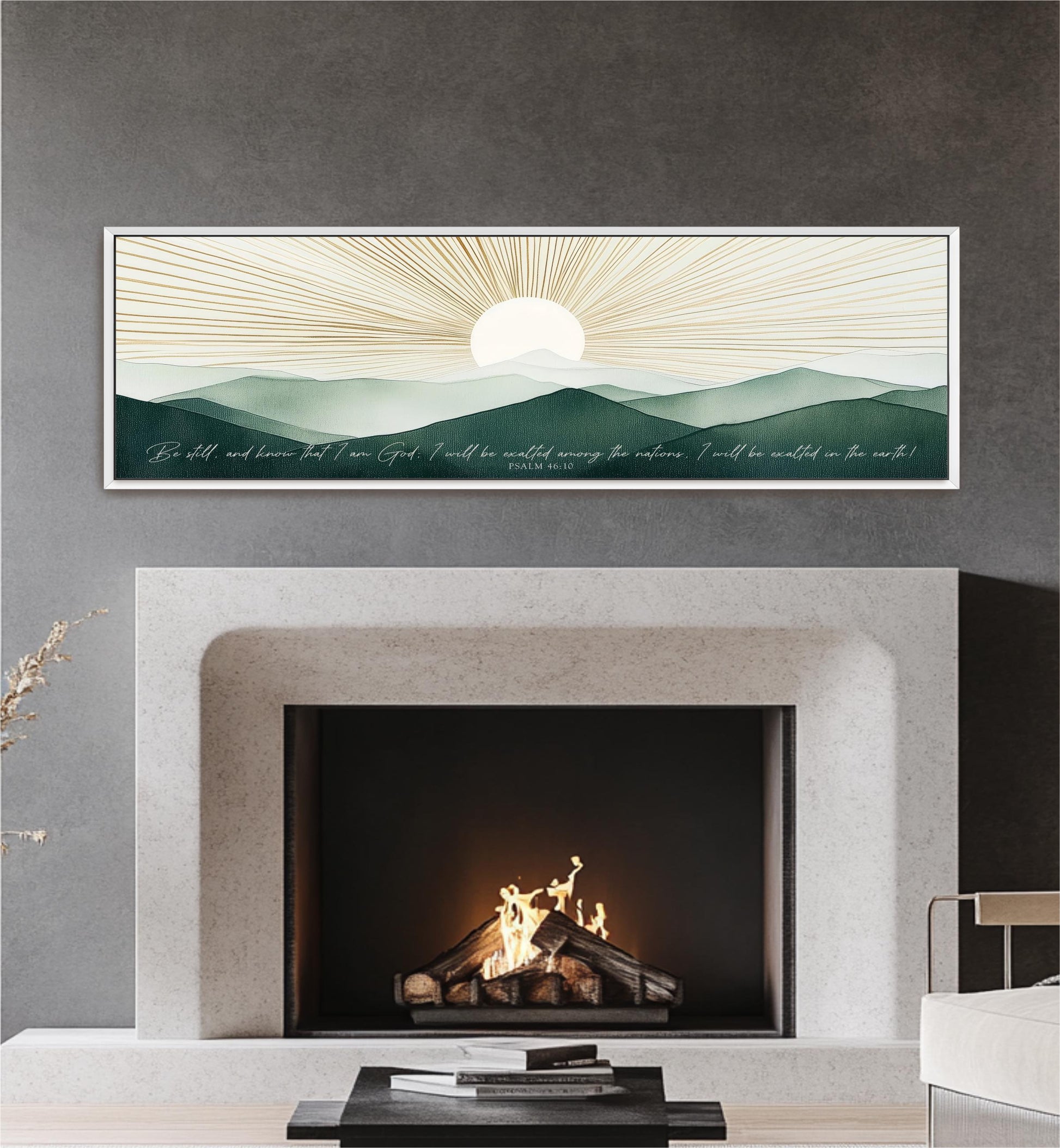 a fireplace with a warm fire burning inside, set against a backdrop of a serene landscape with mountains and a sun-like design. Above the fireplace, there is a framed artwork depicting a sunrise or sunset over a mountainous terrain. The artwork is framed in a white frame and hangs on a gray wall.