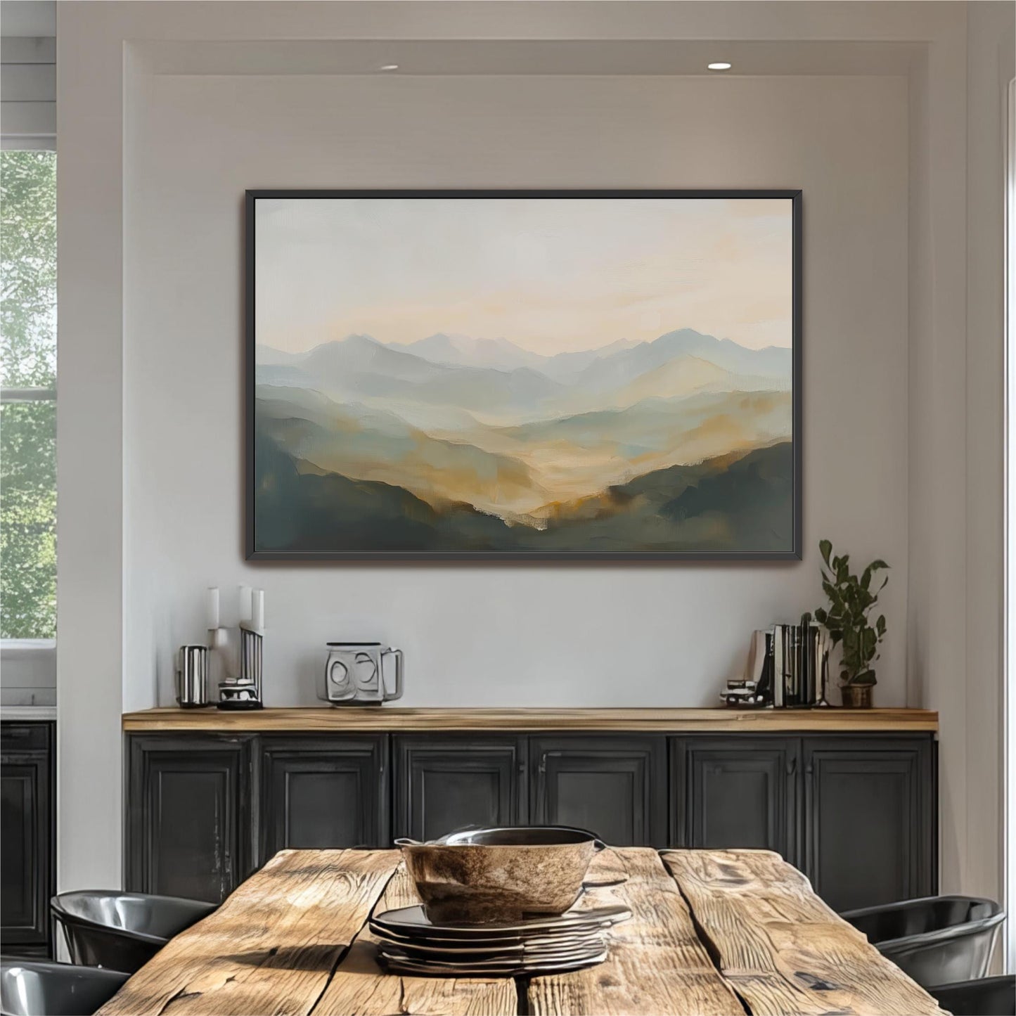 a large painting of a mountain landscape hanging on a wall above a wooden dining table with a bowl on it.