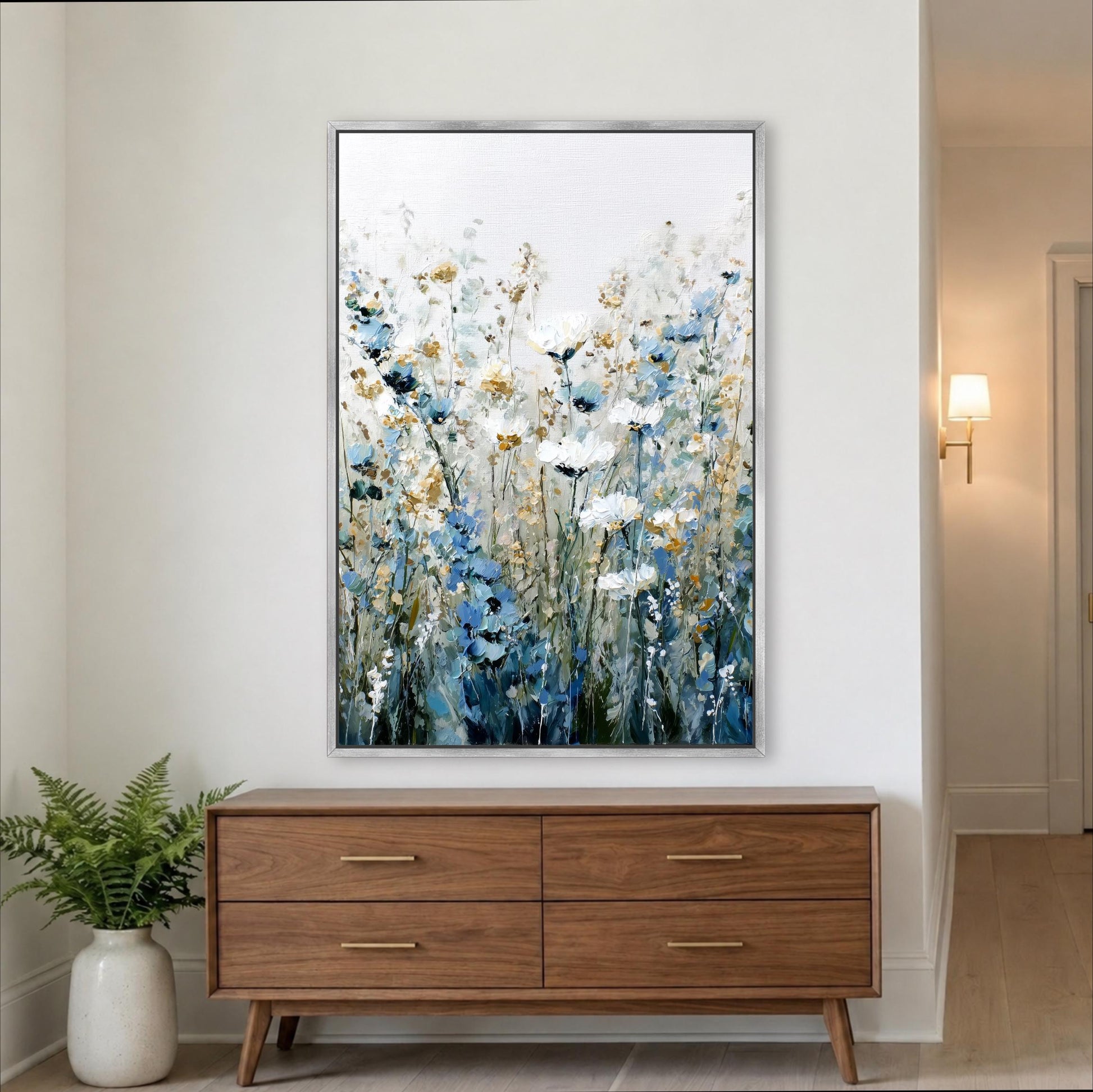 a large painting of flowers hanging on a wall above a wooden dresser with four drawers.