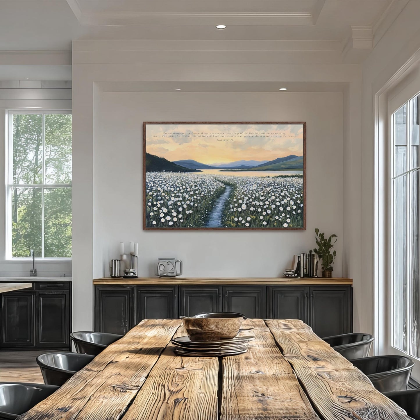 a large painting of a field of flowers hanging on the wall above a wooden dining table with black chairs.