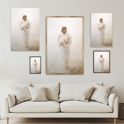 a large framed painting of a woman holding a lamb, with a smaller framed painting of the same woman below it. The painting is set against a white wall, and there is a white sofa in the foreground.