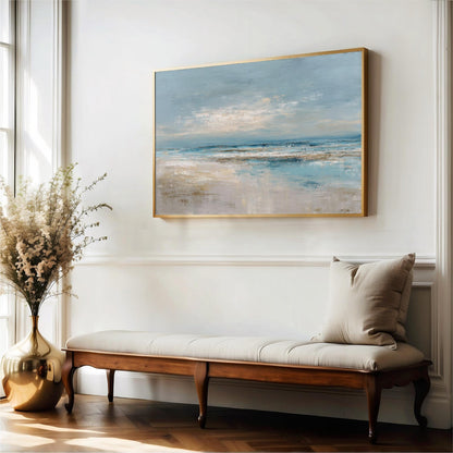 a large painting of a beach scene hanging on a white wall, with a wooden bench and a vase of flowers placed in front of it.