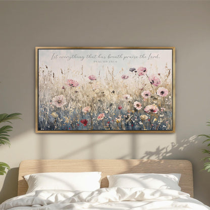 a framed painting of a field of flowers hanging on a wall above a bed with white pillows.