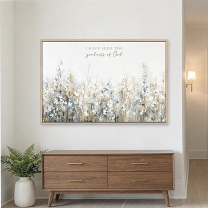 a large framed painting of a field of flowers hanging on a wall above a wooden dresser with four drawers.
