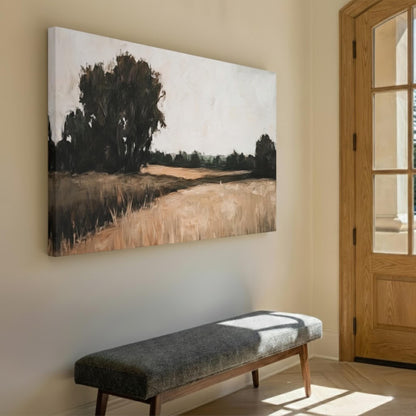 a large painting of a field with trees hanging on a wall, and a gray bench is positioned in front of it.