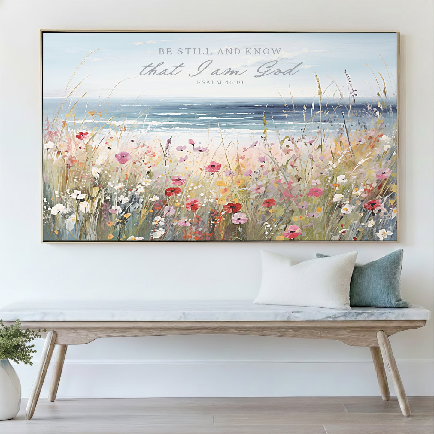 a large framed painting of a field of flowers hanging on a wall above a wooden bench.