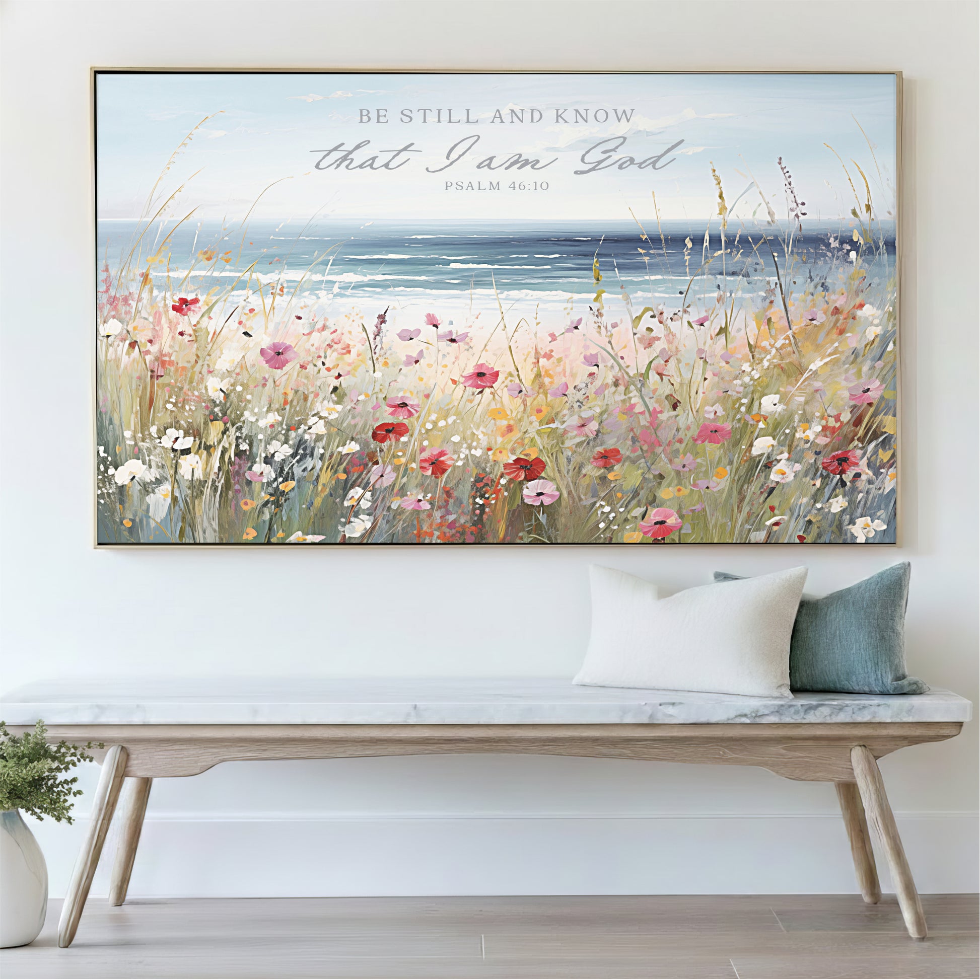 a large framed painting of a field of flowers hanging on a wall above a wooden bench.