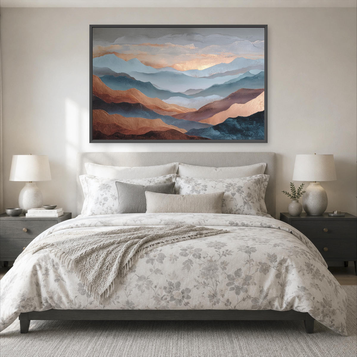 a serene bedroom scene with a large bed adorned with a floral comforter and pillows, flanked by two nightstands with lamps. Above the bed, a large framed painting of a mountain landscape with a gradient of colors is displayed on the wall.