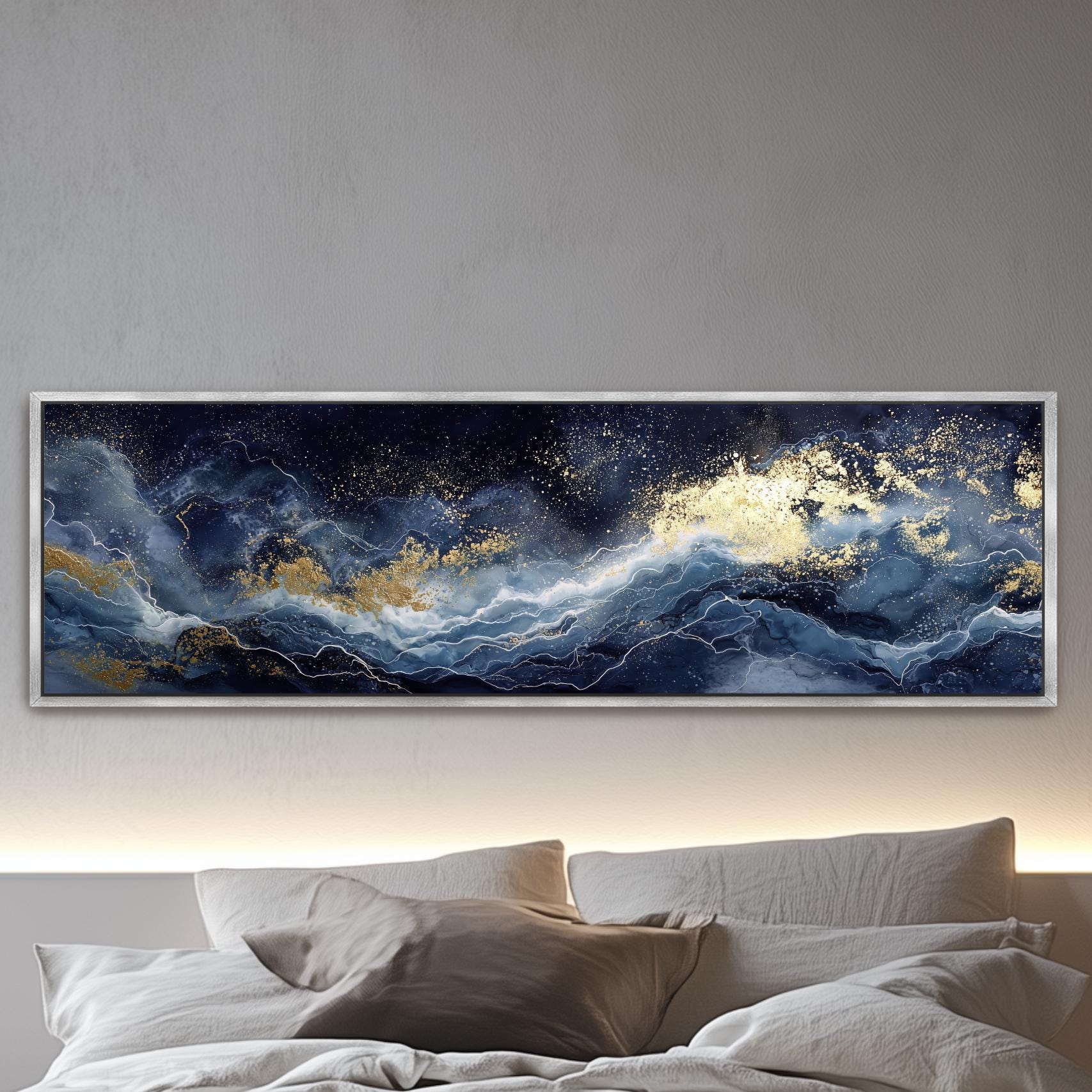 a large, framed painting of a night sky with swirling clouds and stars, hanging above a bed with white pillows.