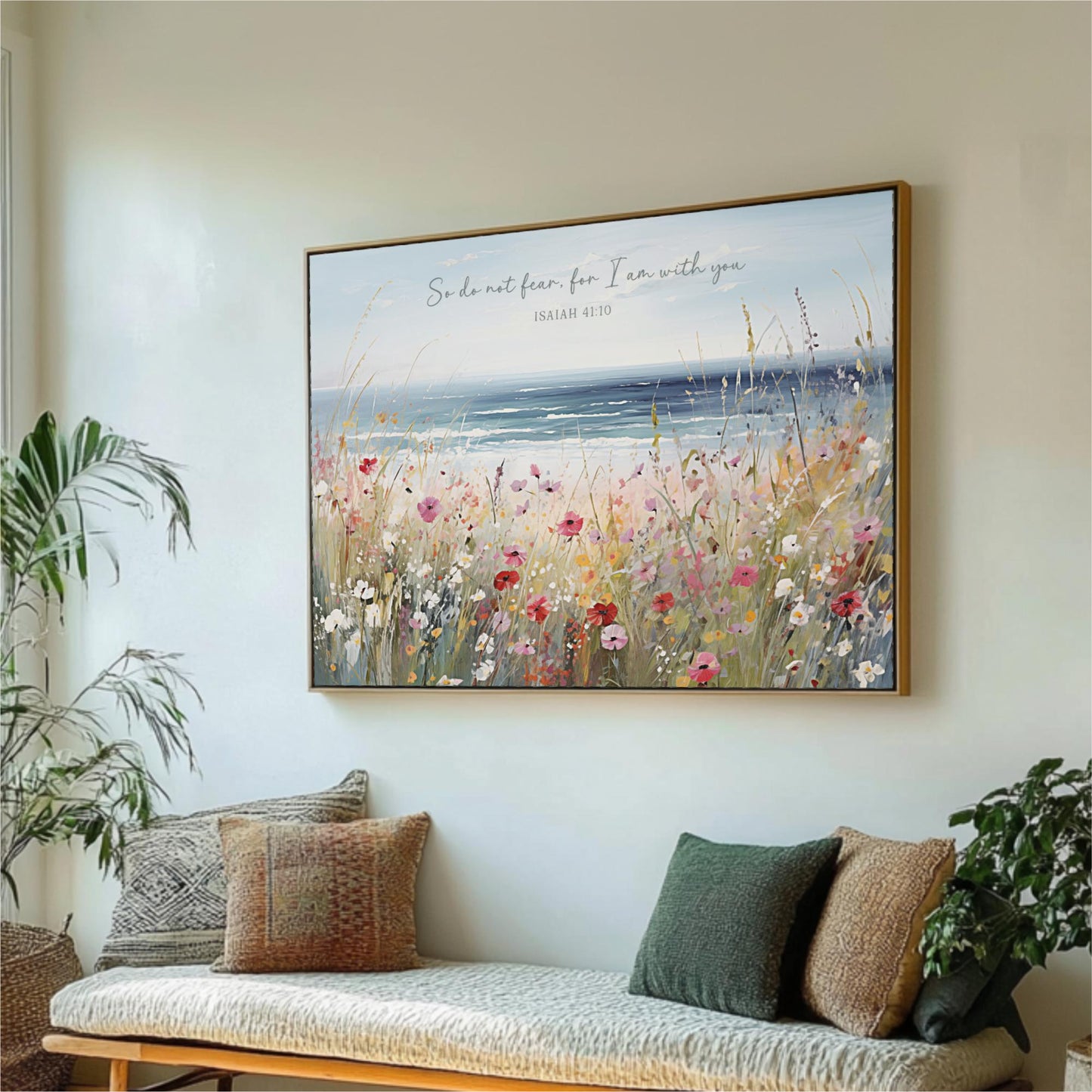a large framed painting of a field of flowers hanging on a wall, with a bench and potted plants in the foreground.