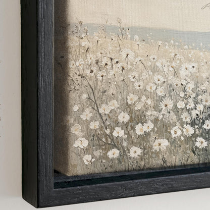The image is a painting of a field of white flowers, with the flowers appearing to be in various stages of bloom. The painting is framed in a black frame and is displayed on a wall.