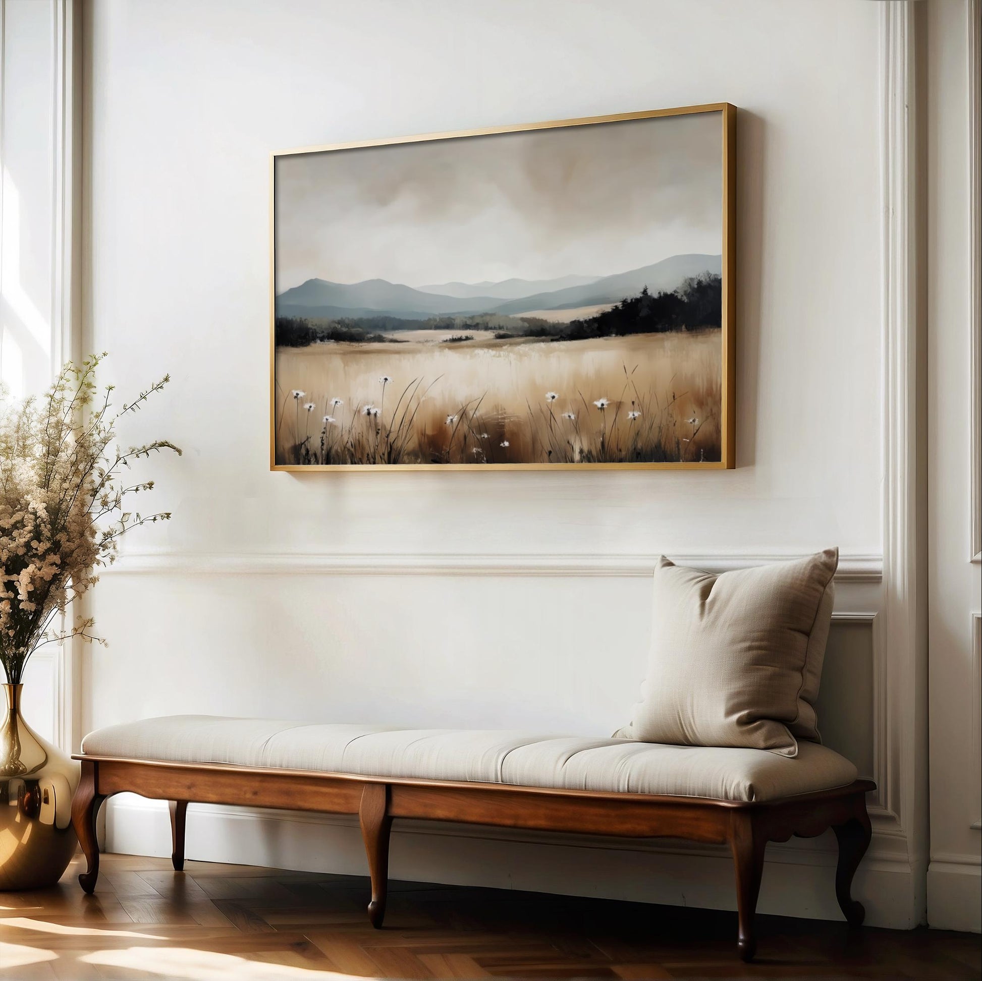 a large landscape painting hanging on a white wall above a wooden bench with a beige cushion.
