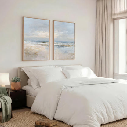 a serene bedroom with a large bed, white bedding, and two framed landscape paintings on the wall above it.