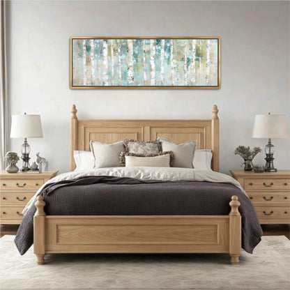 a serene and cozy bedroom with a large bed, wooden headboard, and two nightstands with lamps. Above the bed, there is a large painting of trees with a blue and green color scheme. The room has a neutral color palette, with the gray bedding and the wooden furniture creating a warm and inviting atmosphere.