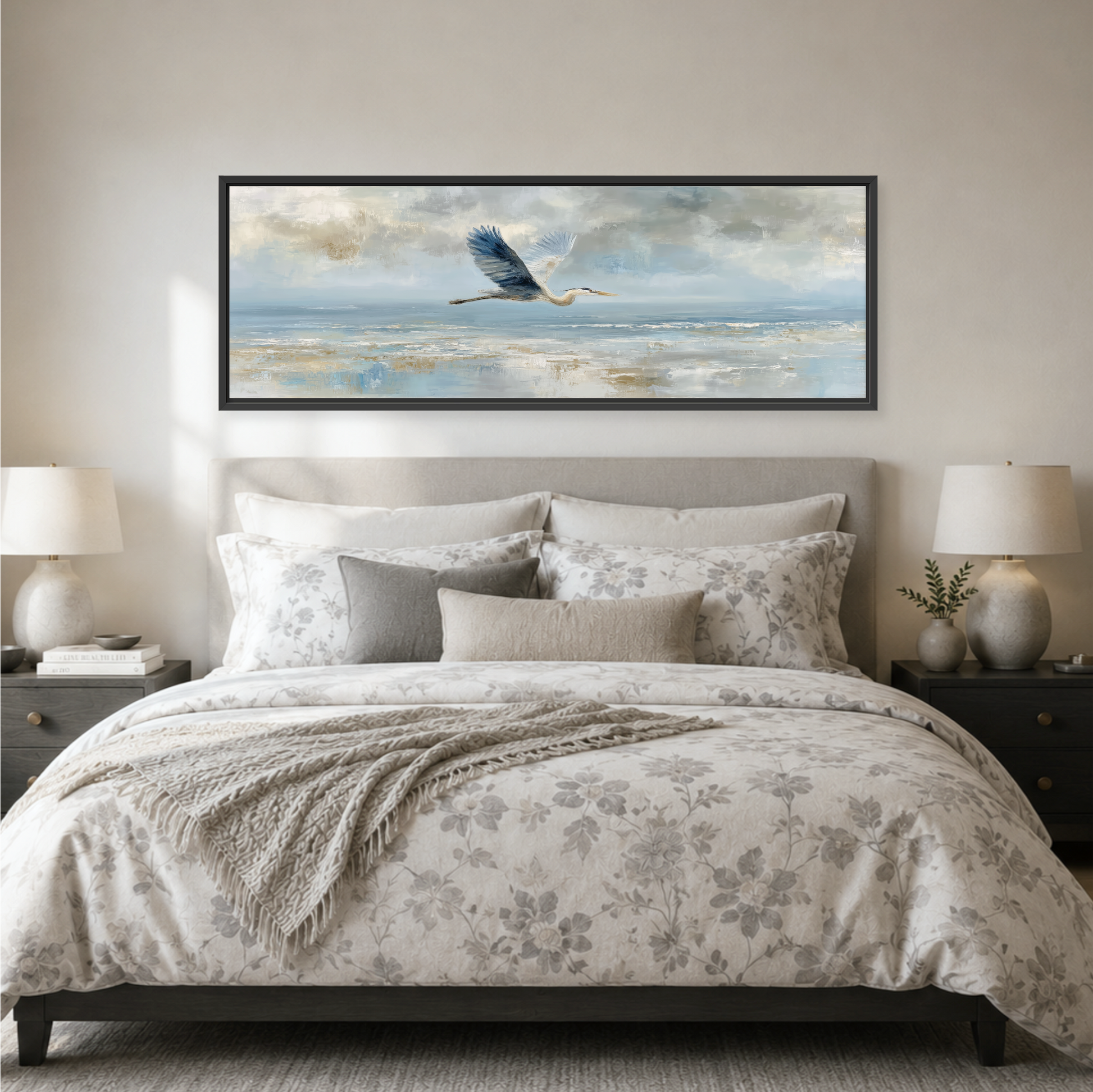 a serene bedroom scene with a large bed adorned with a floral comforter and pillows, flanked by two nightstands with lamps. Above the bed, a large framed painting of a bird in flight is displayed on the wall, creating a calming and peaceful atmosphere.