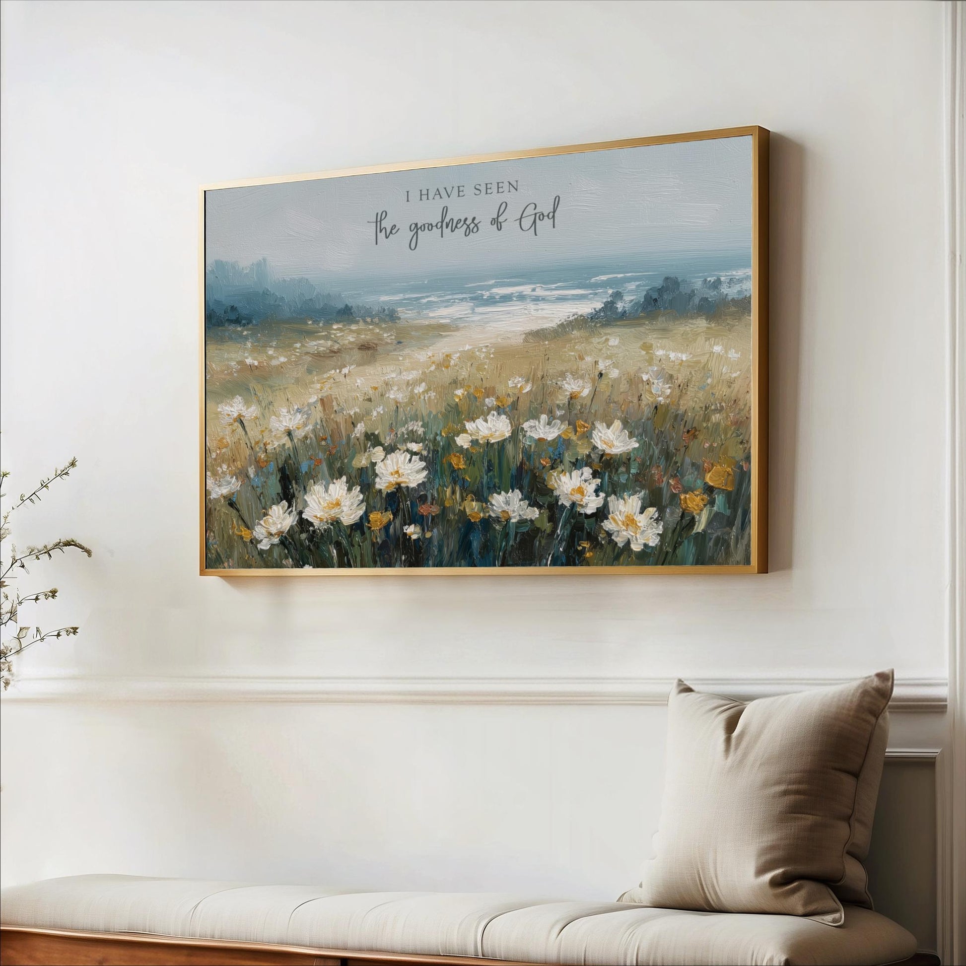 a painting of a field of flowers hanging on a wall, with a bench and a plant in the foreground.