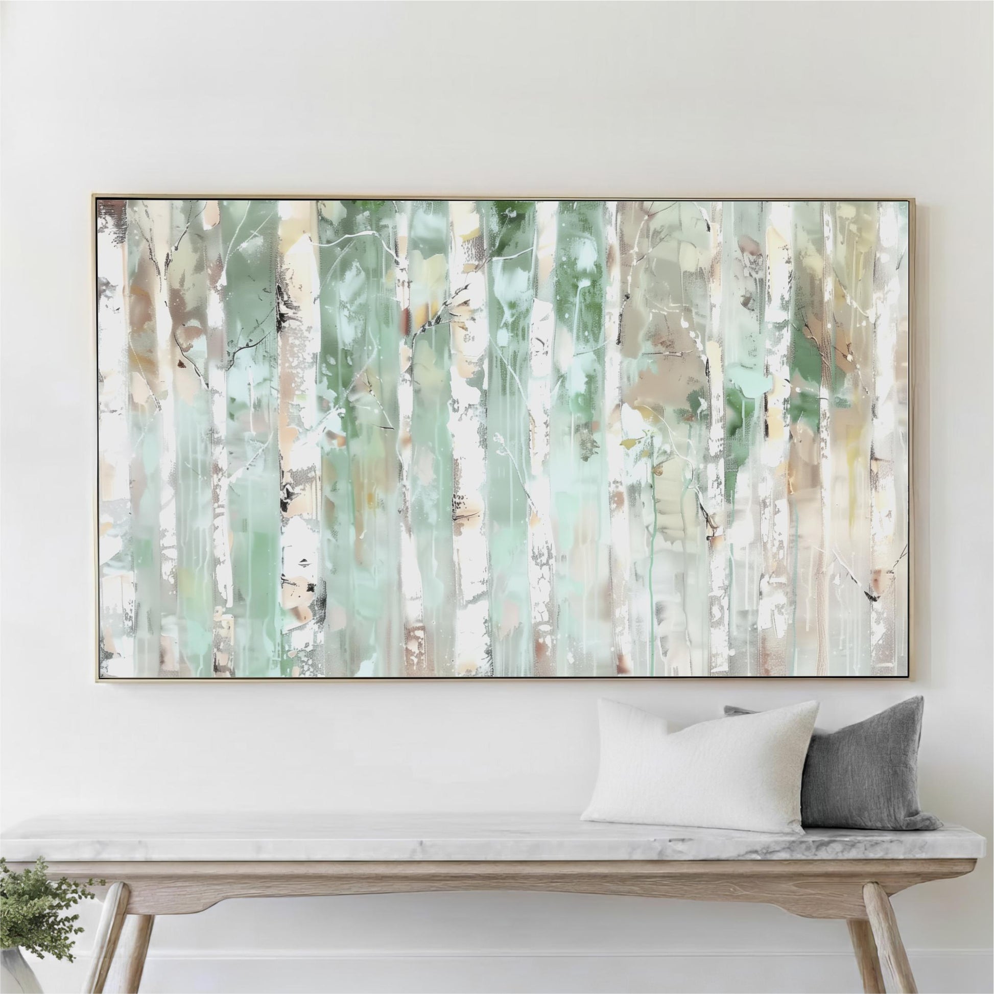 a large abstract painting hanging on a white wall above a wooden bench with two pillows.