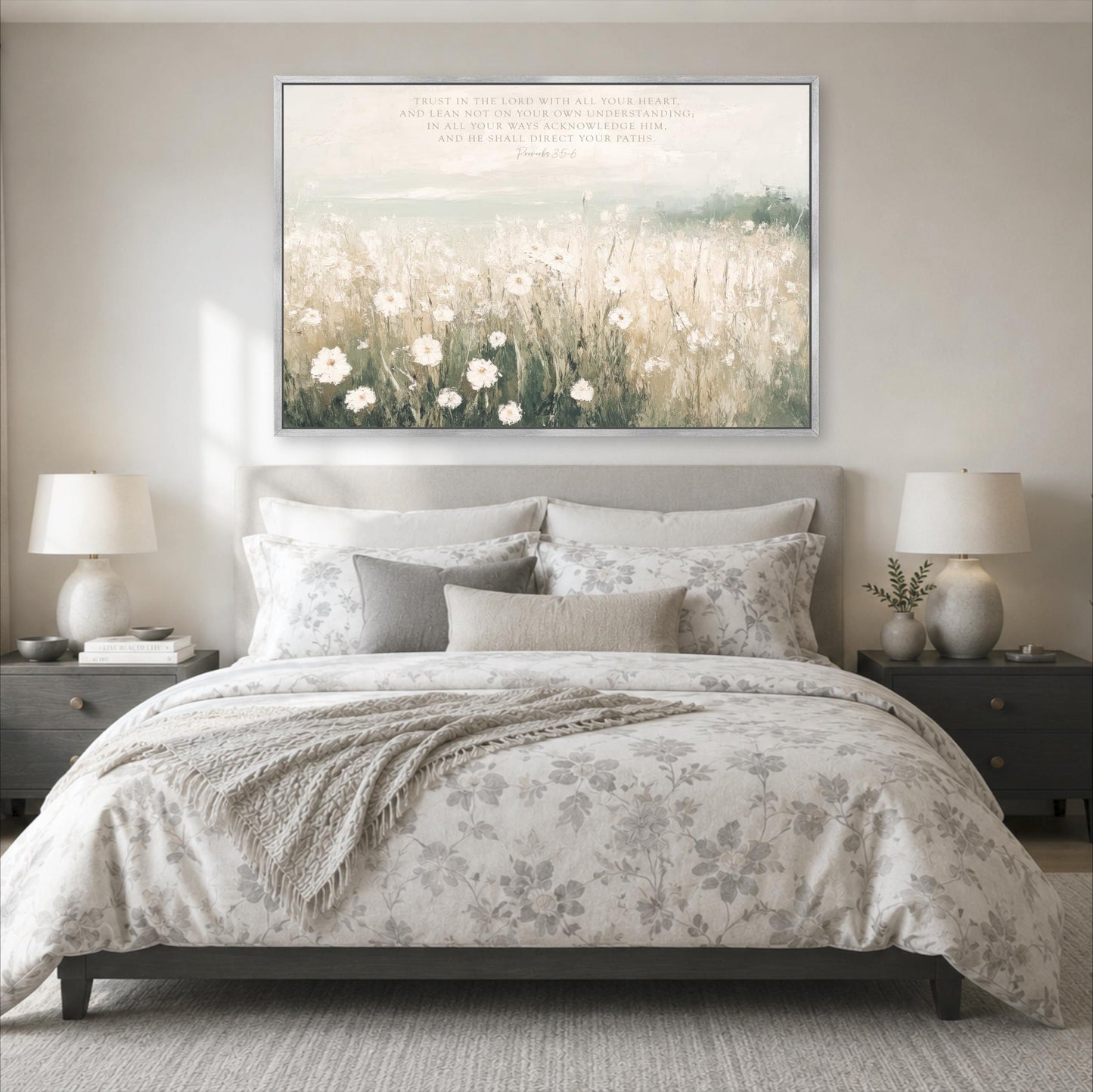 a serene bedroom scene with a large bed adorned with a floral comforter and pillows, flanked by two nightstands with lamps. Above the bed, a large framed print of a field of flowers serves as a decorative focal point.