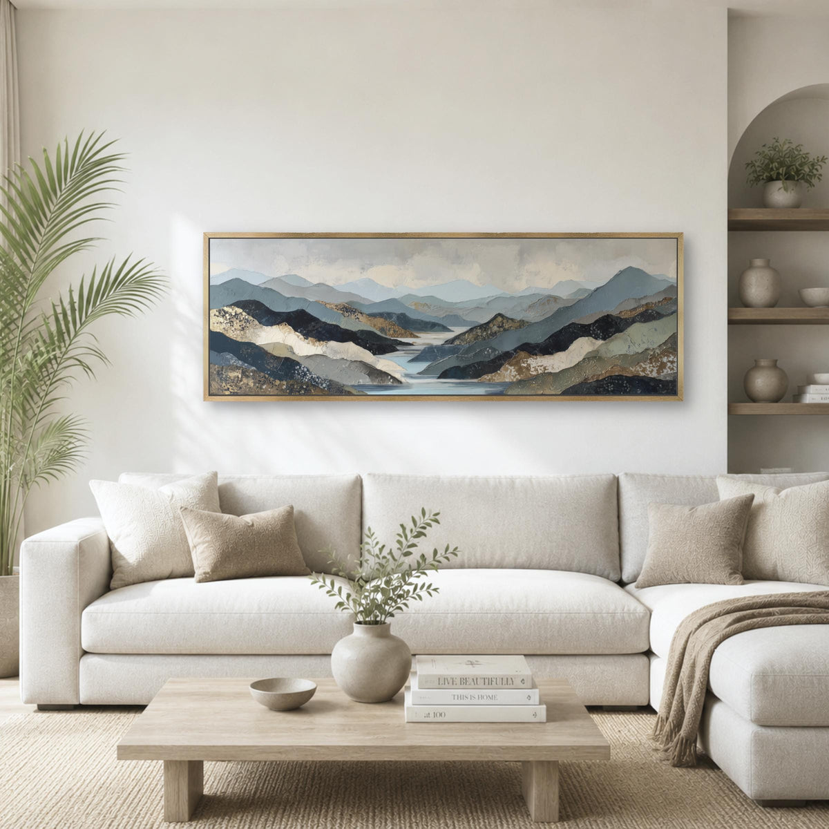 a serene living room with a large, framed landscape painting hanging on the wall above a white sofa. The painting features a mountainous scene with a lake in the background. The room is decorated with a wooden coffee table, a potted plant, and a vase with greenery.