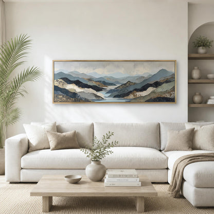 a serene living room with a large, framed landscape painting hanging on the wall above a white sofa. The painting features a mountainous scene with a lake in the background. The room is decorated with a wooden coffee table, a potted plant, and a vase with greenery.