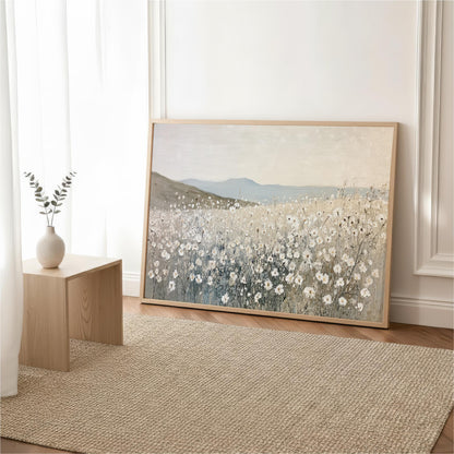 a large painting of a field of flowers, with a vase of flowers placed on a wooden table next to it.