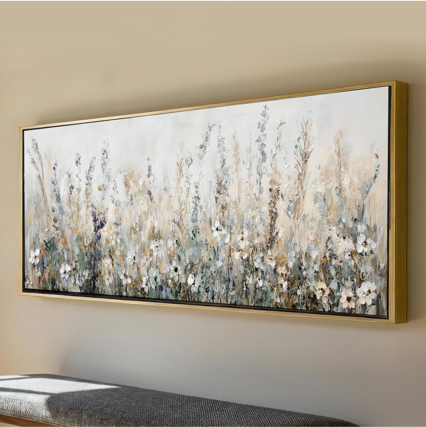 a large, framed painting of a field of flowers hanging on a wall.