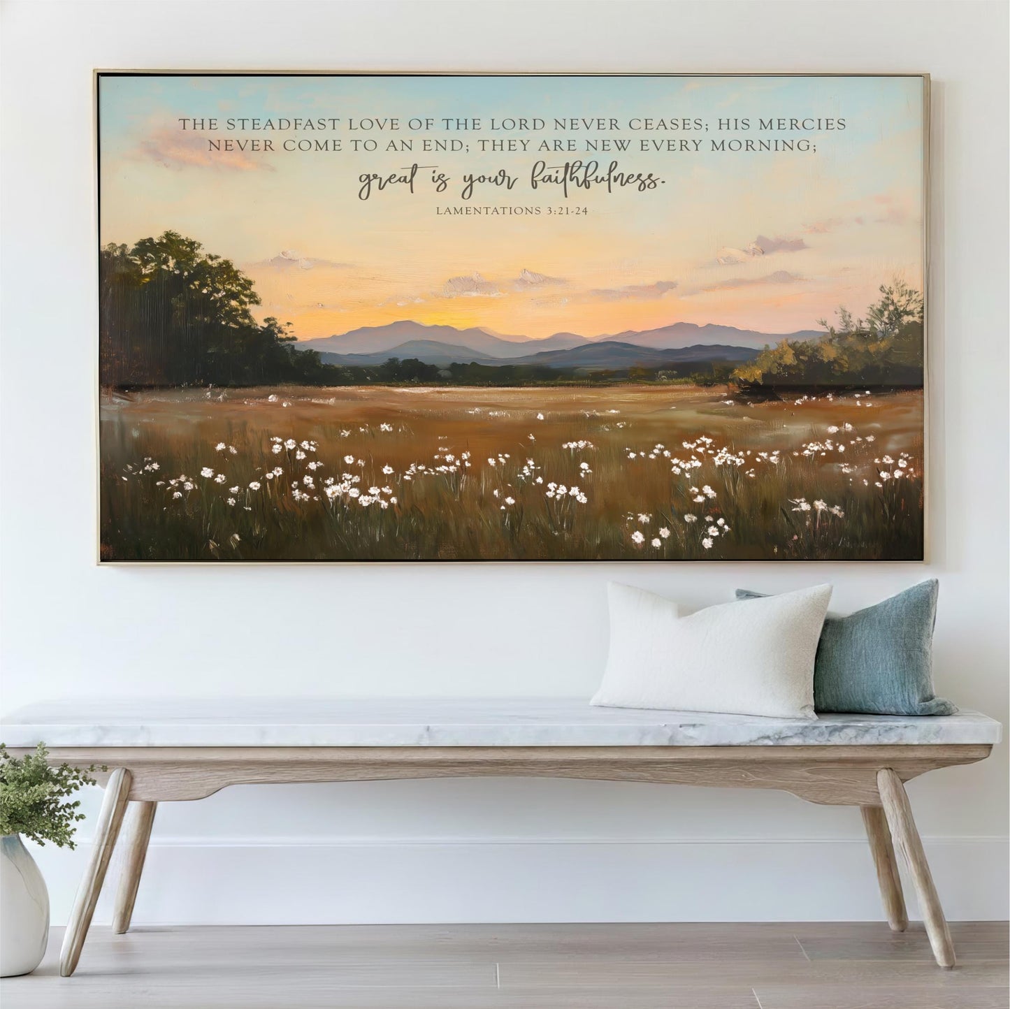 a large painting of a field with flowers and mountains in the background, hanging on a wall above a wooden bench with pillows.