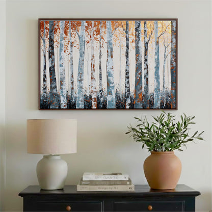 a wooden cabinet with a lamp, a potted plant, and a framed painting of trees hanging on the wall above it.
