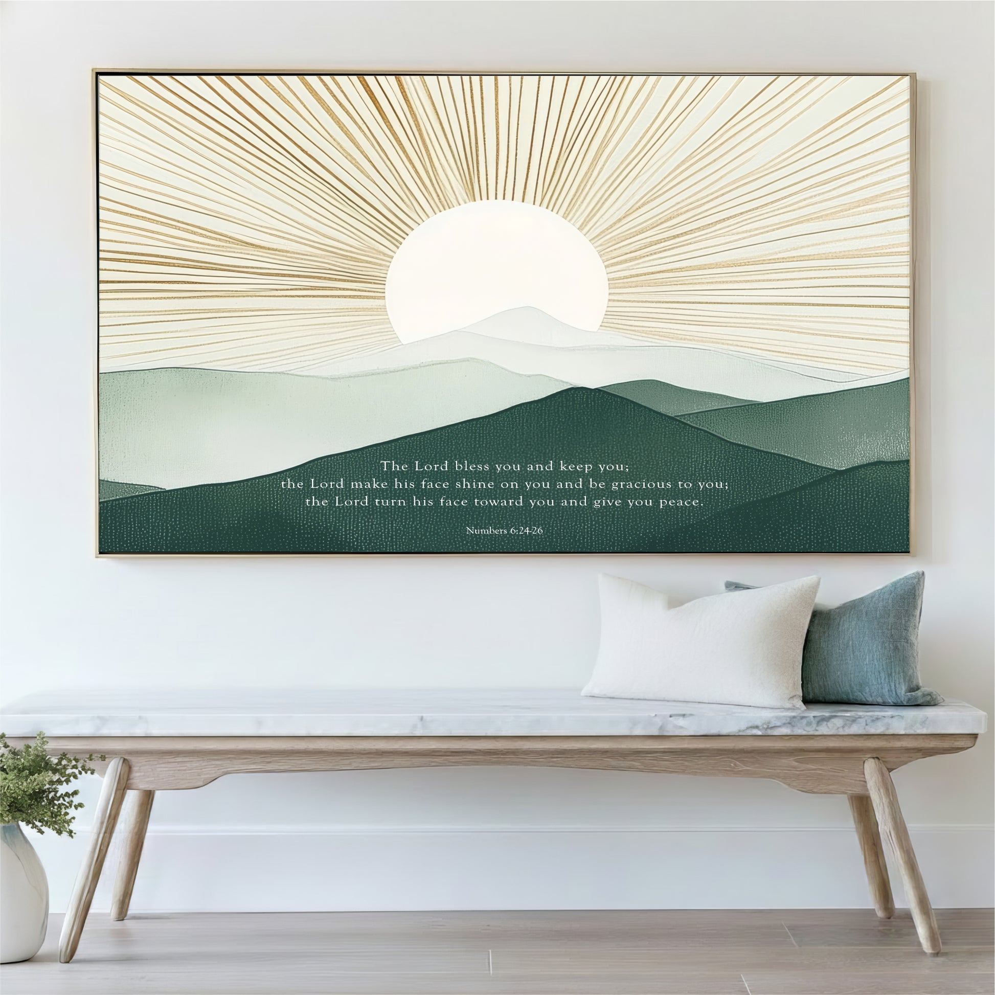 a large framed artwork depicting a serene landscape with a sun rising over a mountain range. The artwork is mounted on a wall above a wooden bench, which has a white cushion on it. The overall scene conveys a sense of tranquility and natural beauty.